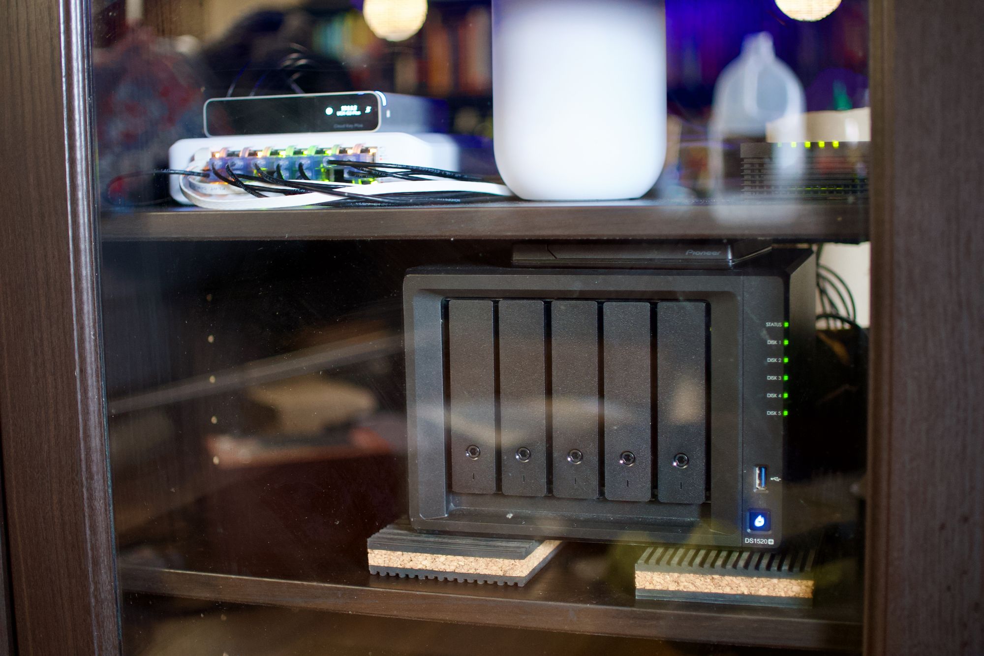 Photo of my Synology DS1520+ NAS server nested in my IKEA cabinet on a middle shelf, sitting on cork pads.