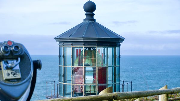 Cape Meares Lighthouse stands above the Pacific Ocean at a viewpoint in coastal Oregon